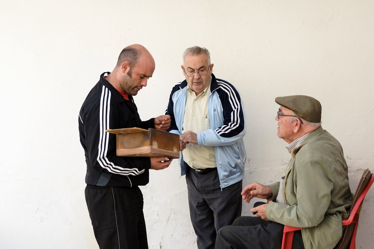 Tres aficionats i el trinqueter a la paret del trinquet, un dia de partida del maig de 2017