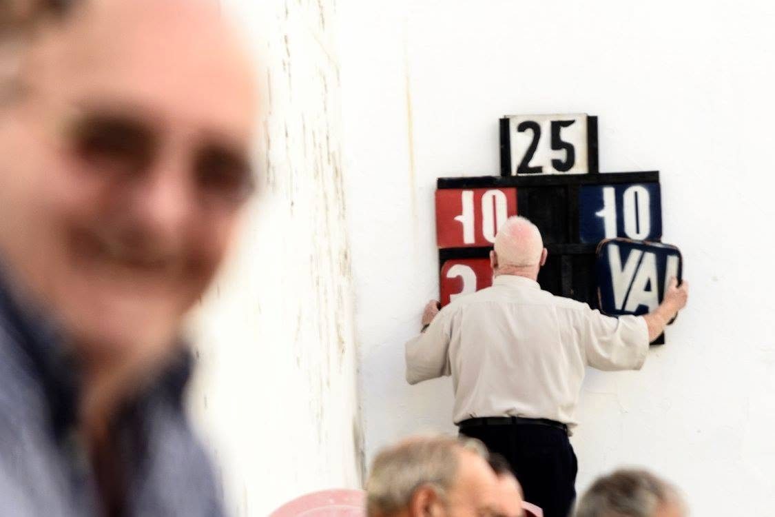 Un aficionat posant el marcador, 10 a 10, en una partida del maig de 2017